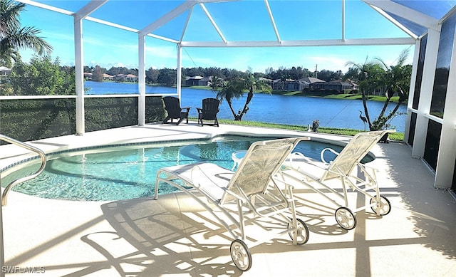 view of pool with a water view, glass enclosure, and a patio area