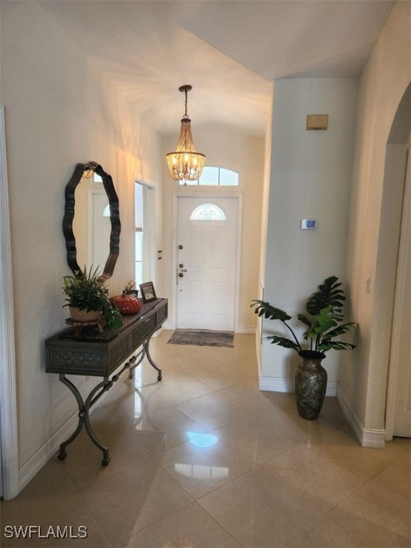 tiled foyer featuring a notable chandelier