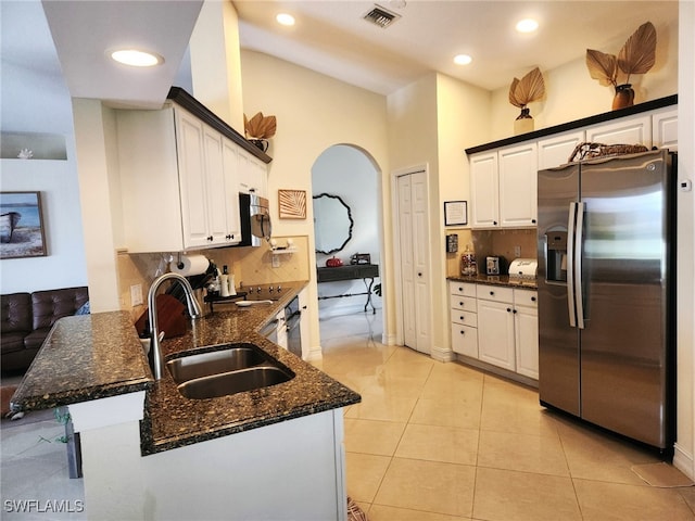 kitchen featuring sink, stainless steel refrigerator with ice dispenser, kitchen peninsula, decorative backsplash, and white cabinets