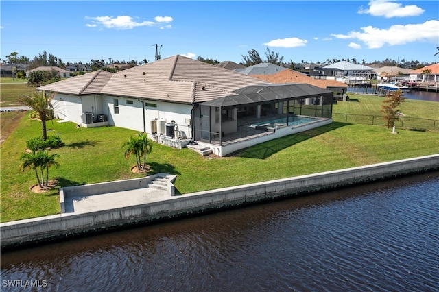 back of house featuring a lanai, central AC unit, a lawn, and a water view