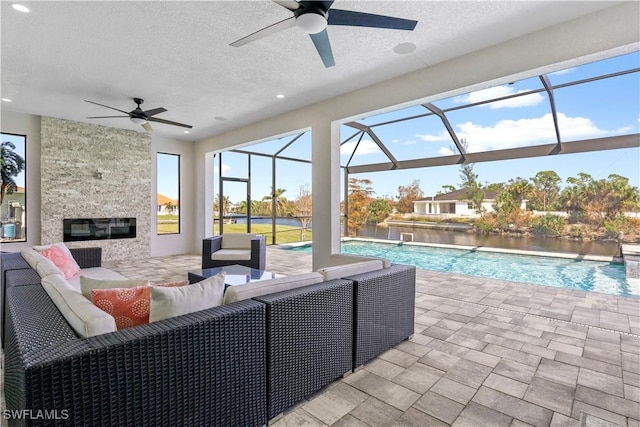 exterior space featuring an outdoor living space, a patio area, a lanai, and ceiling fan