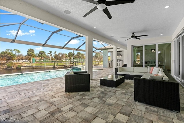 view of patio featuring ceiling fan, glass enclosure, and an outdoor hangout area