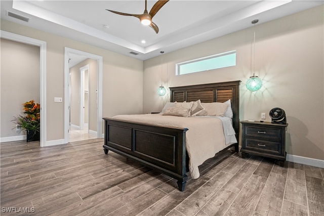 bedroom featuring ceiling fan and a tray ceiling