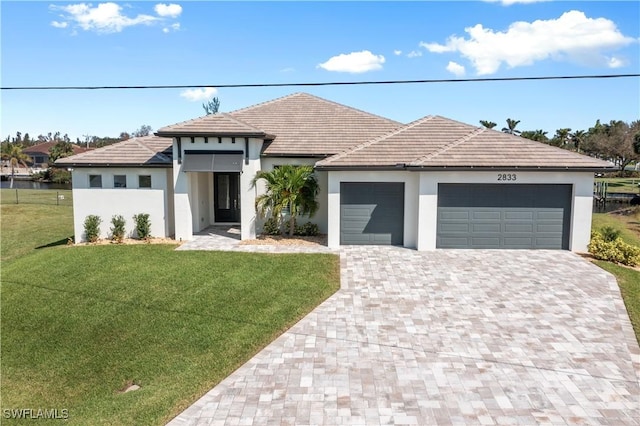 view of front of property with a garage and a front lawn