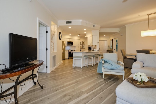 living room with crown molding and light hardwood / wood-style floors