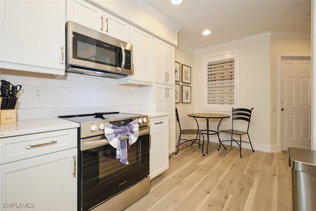 kitchen with decorative backsplash, light hardwood / wood-style flooring, white cabinetry, and stainless steel appliances