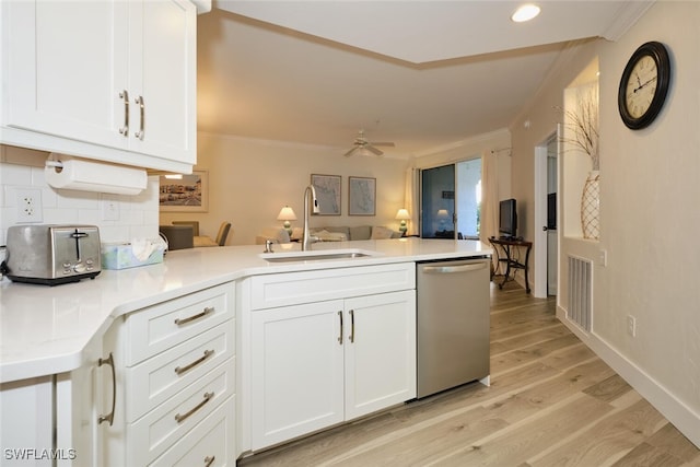 kitchen featuring sink, kitchen peninsula, white cabinetry, light hardwood / wood-style floors, and stainless steel dishwasher