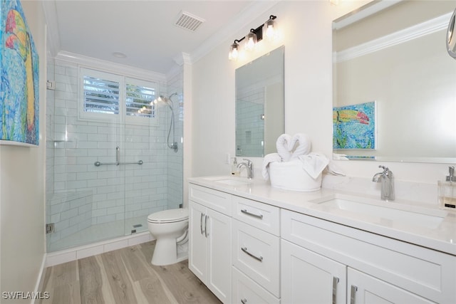 bathroom with an enclosed shower, hardwood / wood-style flooring, toilet, vanity, and crown molding