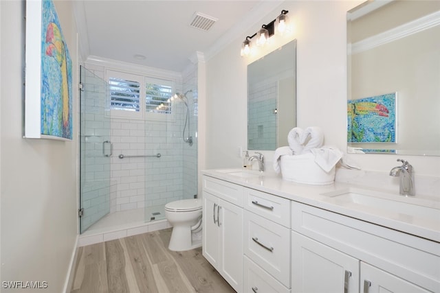 bathroom featuring vanity, crown molding, wood-type flooring, and toilet