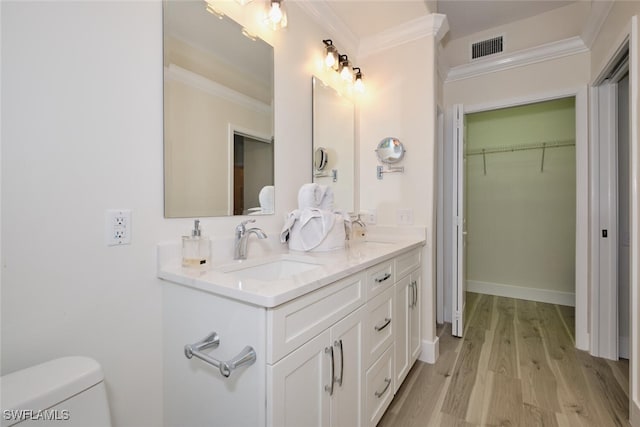 bathroom featuring vanity, toilet, ornamental molding, and hardwood / wood-style floors