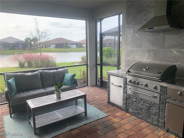 view of patio / terrace with an outdoor kitchen, a water view, and grilling area