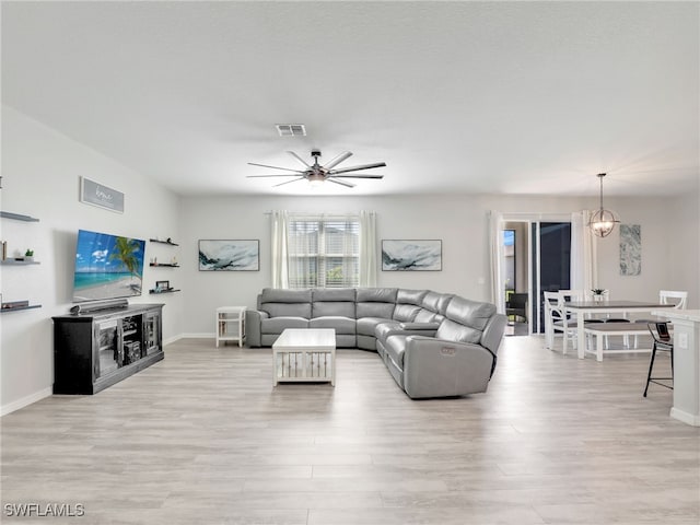 living room with light hardwood / wood-style flooring and ceiling fan with notable chandelier