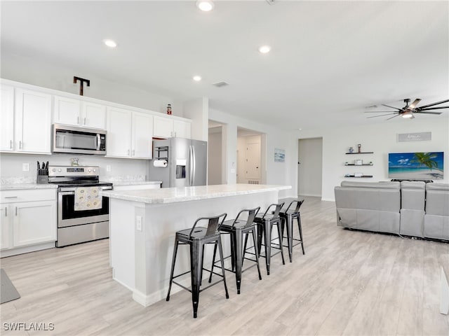 kitchen with white cabinets, a center island, and stainless steel appliances