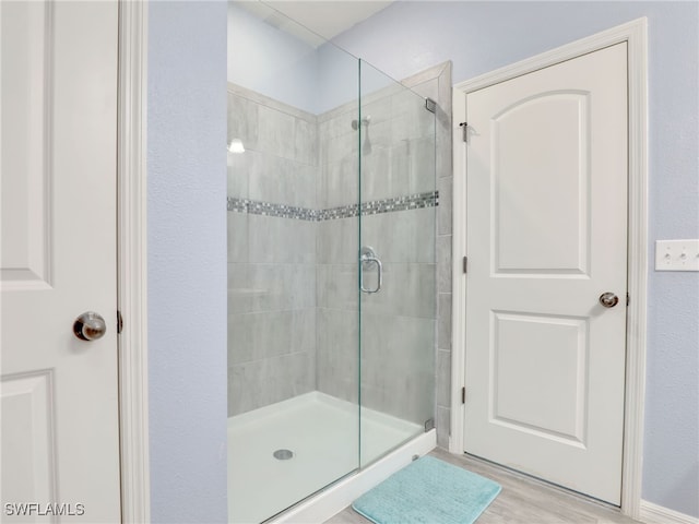 bathroom featuring hardwood / wood-style floors and a shower with shower door