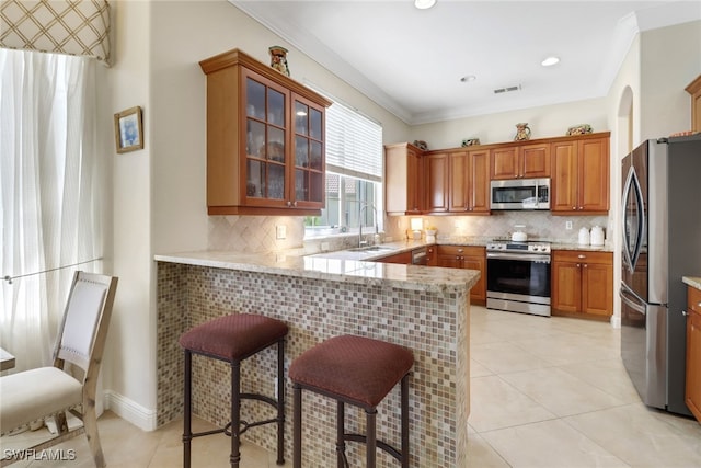 kitchen featuring crown molding, stainless steel appliances, decorative backsplash, and light tile patterned floors