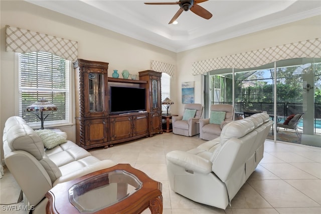 tiled living room featuring crown molding, a tray ceiling, and ceiling fan