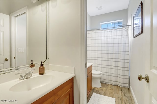 bathroom with vanity, curtained shower, hardwood / wood-style flooring, and toilet