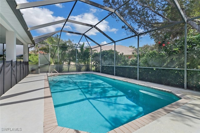 view of swimming pool with a patio area and a lanai