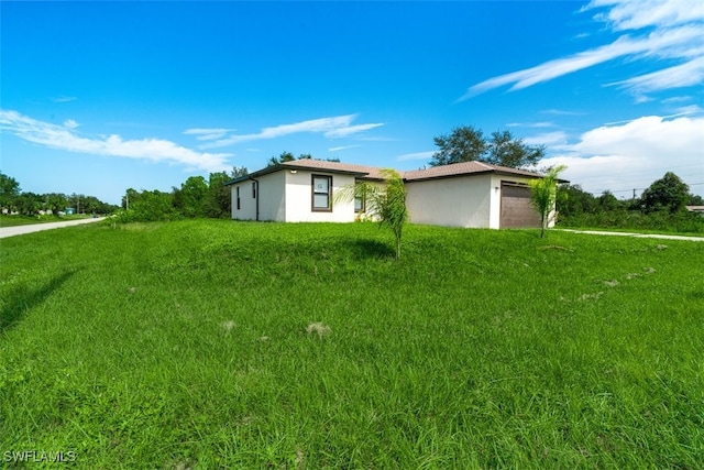 view of side of home with a garage and a lawn