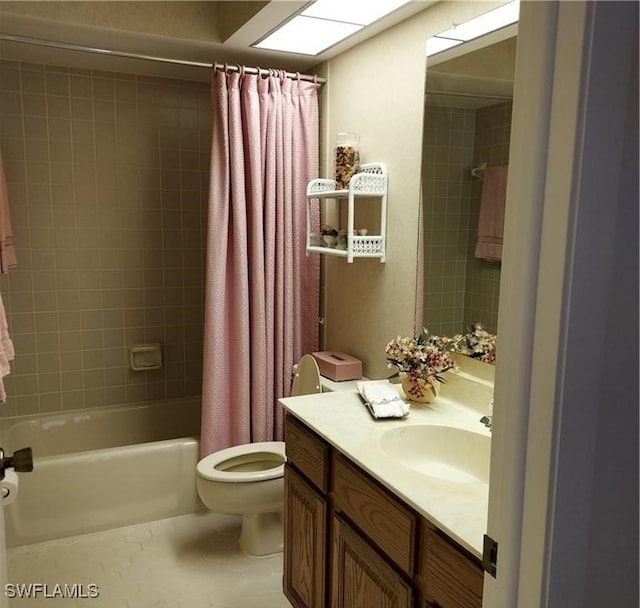 full bathroom featuring tile patterned floors, shower / bath combo with shower curtain, vanity, and toilet