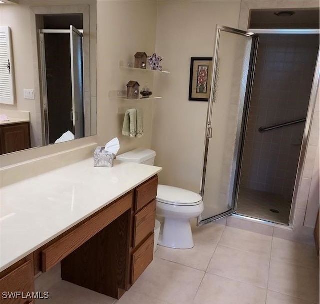 bathroom with tile patterned floors, a shower with door, vanity, and toilet