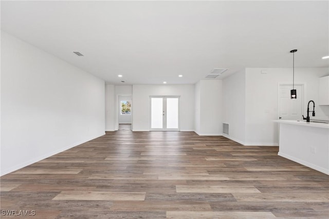 164 Thornton Ave S, Lehigh Acres, FL 33974 - unfurnished living room with sink, wood-type flooring, and french doors