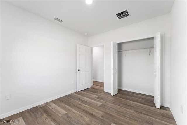 164 Thornton Ave S, Lehigh Acres, FL 33974 - unfurnished bedroom with dark wood-type flooring and a closet