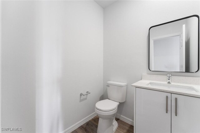 164 Thornton Ave S, Lehigh Acres, FL 33974 - bathroom featuring vanity, hardwood / wood-style flooring, and toilet
