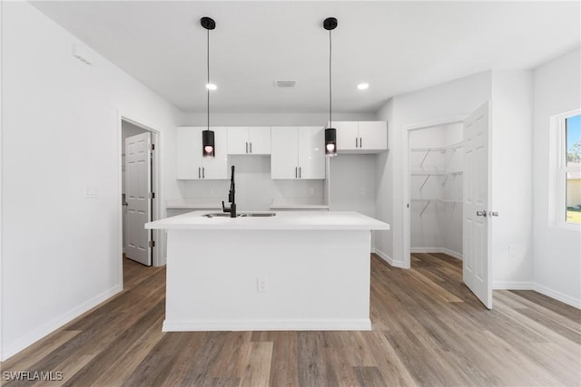 164 Thornton Ave S, Lehigh Acres, FL 33974 - kitchen with sink, a kitchen island with sink, hanging light fixtures, white cabinets, and light wood-type flooring
