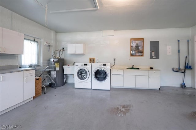 clothes washing area with cabinets, electric panel, washing machine and clothes dryer, water heater, and sink