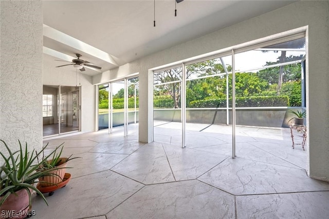 unfurnished sunroom with ceiling fan