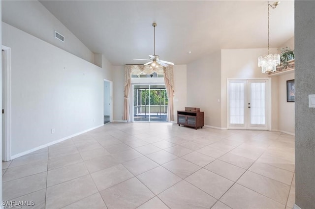 unfurnished living room featuring french doors, high vaulted ceiling, light tile patterned floors, and ceiling fan with notable chandelier