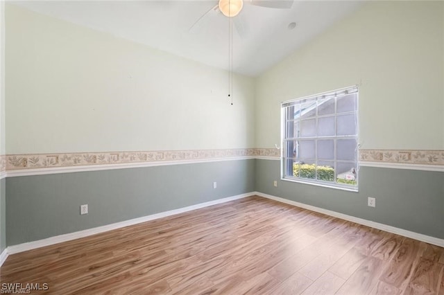 spare room featuring lofted ceiling, light wood-type flooring, and ceiling fan