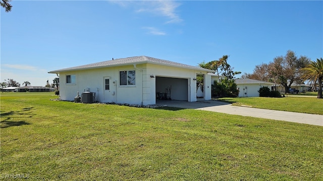 view of front of home featuring cooling unit, a front lawn, and a garage