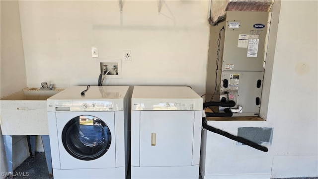 washroom featuring sink, washer and clothes dryer, and heating unit