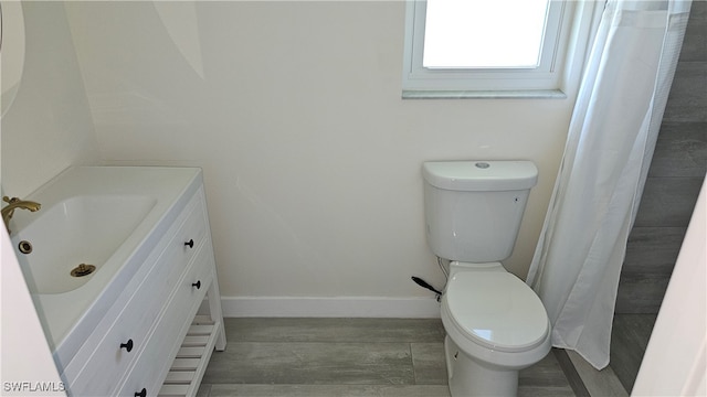 bathroom with vanity, toilet, wood-type flooring, and a shower with curtain