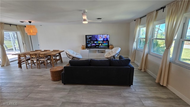 living room featuring ceiling fan and a wealth of natural light