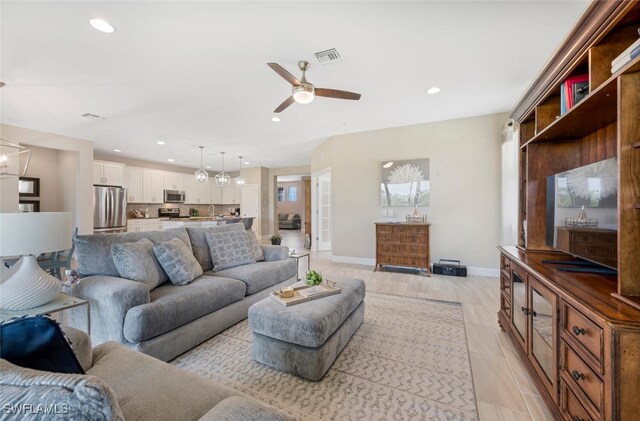 living room featuring light wood-type flooring and ceiling fan