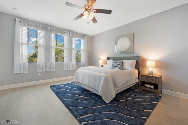 bedroom with hardwood / wood-style flooring, lofted ceiling, and ceiling fan