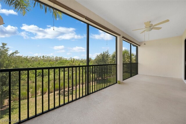 unfurnished sunroom featuring ceiling fan