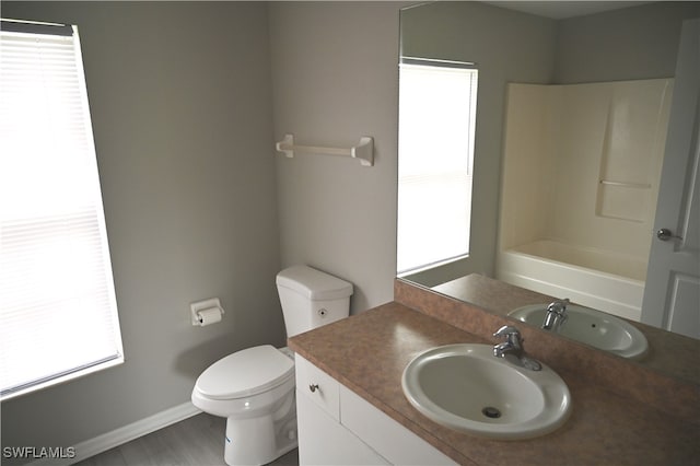 bathroom with toilet, vanity, and a wealth of natural light