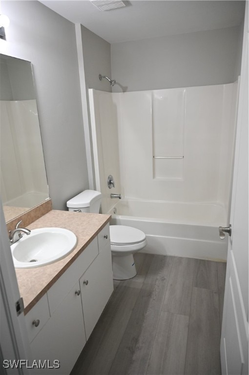 full bathroom featuring vanity, toilet, shower / bathtub combination, and hardwood / wood-style floors