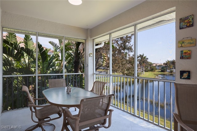 sunroom featuring a water view