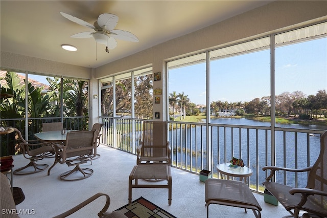 sunroom / solarium featuring a water view and ceiling fan