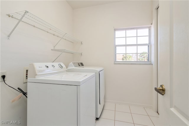 laundry area featuring separate washer and dryer and light tile patterned floors