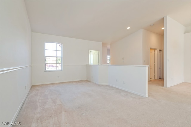 carpeted empty room featuring lofted ceiling