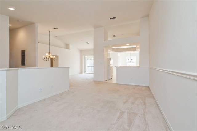 spare room with light carpet, electric panel, and a chandelier