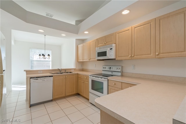 kitchen featuring white appliances, sink, light brown cabinets, hanging light fixtures, and a chandelier