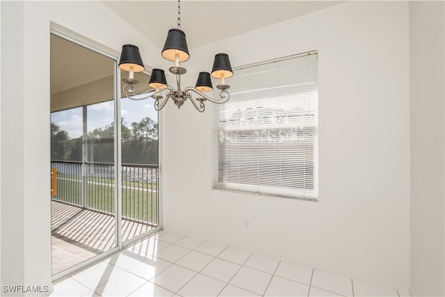 unfurnished dining area featuring an inviting chandelier and tile patterned flooring