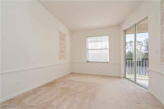 carpeted empty room featuring lofted ceiling, a water view, and a wealth of natural light